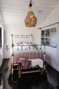 a bedroom with a bed and a chandelier at Bushy Summers - A Nurturing Bayside Shack in Strahan