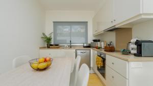 a kitchen with a bowl of fruit on a table at DuskLine Villa by LovelyStay in Arco da Calheta