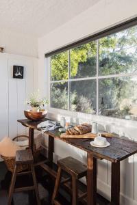 a kitchen with a table and a large window at Bushy Summers - A Nurturing Bayside Shack in Strahan