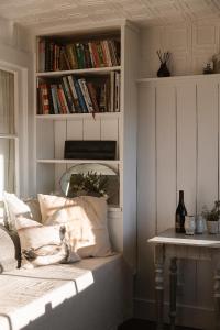 a room with a book shelf filled with books at Bushy Summers - A Nurturing Bayside Shack in Strahan