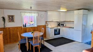 a kitchen with a table and a table and chairs at Glad hund in Dalskog