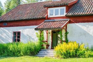 a small white house with a red roof and stairs at Charming Farmhouse in Gammelbo