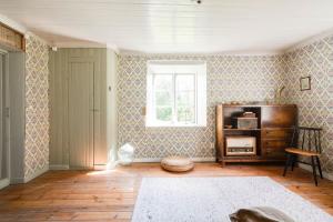 a living room with a dresser and a window at Charming Farmhouse in Gammelbo
