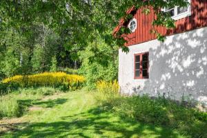 a white building with a red roof and a grass yard at Charming Farmhouse in Gammelbo +14 photos