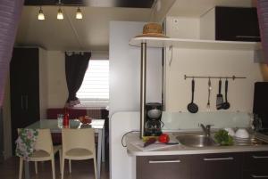 a small kitchen with a sink and a table at Camping Tikayan Clau Mar Jo - Maeva in Bormes-les-Mimosas