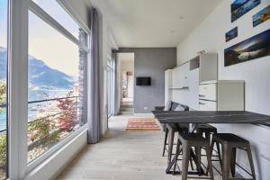 a kitchen with a table and chairs and a large window at B&B Nest on the Lake in Lezzeno