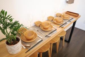 a wooden table with plates and silverware on it at Kyo-wa Hotel Oshiage in Tokyo