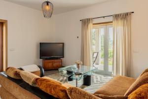 a living room with a couch and a glass table at Mirador House in Vila Garcia