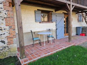 a table and two chairs on a brick patio at Nid de Coucou in Cernoy-en-Berry