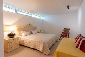 a bedroom with a bed and a lamp and a chair at Mirador House in Vila Garcia