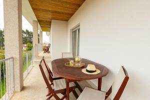 a wooden table and chairs on a balcony at Mirador House in Vila Garcia