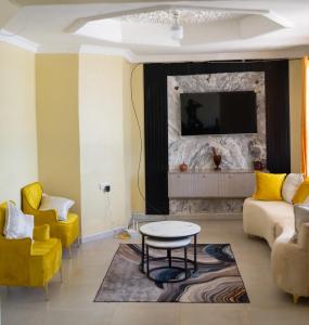 a living room with yellow chairs and a table at The Residence in Lilongwe