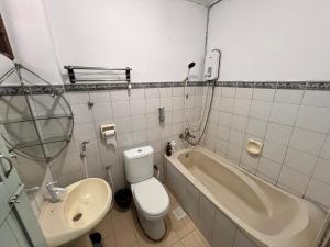 a bathroom with a toilet and a sink and a tub at Aznah’s Stay in Kuching +14 photos