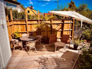 a patio with a table and chairs and an umbrella at Harbor Breeze & Garden Peace in Åhus +5 photos
