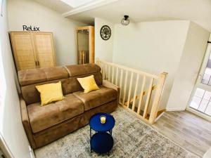 a living room with a brown couch and a staircase at L Oasis Cosy Sauna Privé et Jardin in Bouguenais +41 photos