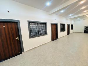 a large empty room with two doors and a window at Skyline Hotel & Banquet in Rewa
