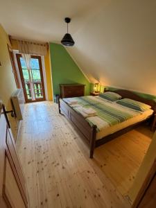 a bedroom with a bed and a wooden floor at Domačija Plesnik in Solčava