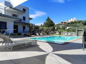 a swimming pool with chairs and a building at Silia Villas in Ormos Panagias