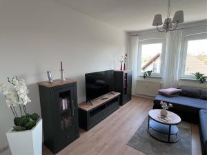 a living room with a blue couch and a tv at Ferienwohnung 1A in Fockendorf