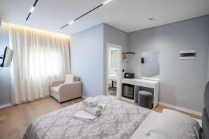a bedroom with a bed and a chair and a mirror at Blue Bay Hotel in Sarandë