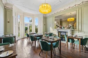 a dining room with tables and chairs and a fireplace at The Torcroft in Torquay