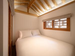 a small bedroom with a bed and a window at Luxury Hanok On169 in Seoul