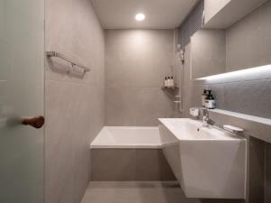 a bathroom with a white sink and a tub and a shower at Luxury Hanok On169 in Seoul