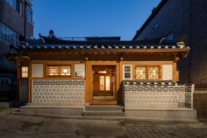 a house with a wooden door and a brick wall at Luxury Hanok On169 in Seoul