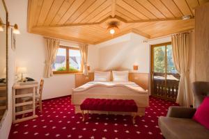 a bedroom with a bed and a red carpet at Hotel Planinka in Ljubno +55 photos