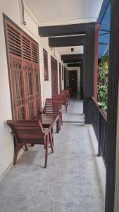 a row of wooden benches sitting on a balcony at Pearl City Resort in Tissamaharama
