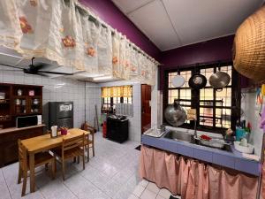 a kitchen with purple walls and a table and a sink at Aznah’s Stay in Kuching