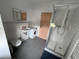 a bathroom with a washing machine and a washer at Ferienwohnung 1A in Fockendorf