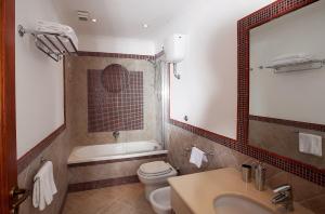 a bathroom with a sink and a toilet and a mirror at Hotel Villa Ceselle in Anacapri