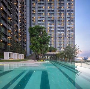 an empty swimming pool in front of a tall building at Lucky 98 Sky Stay in Bang Phli
