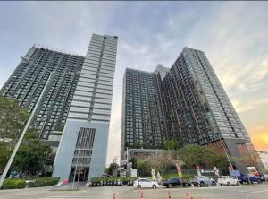 two tall buildings with cars parked in a parking lot at Lucky 98 Sky Stay in Bang Phli
