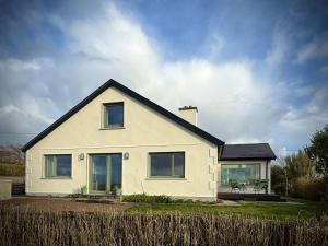 a white house with a black roof at Cottage 498 - Cleggan in Cleggan