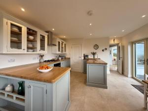a kitchen with white cabinets and a bowl of fruit on a counter at Cottage 498 - Cleggan in Cleggan