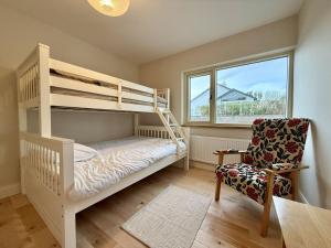 a bedroom with a bunk bed and a chair at Cottage 498 - Cleggan in Cleggan