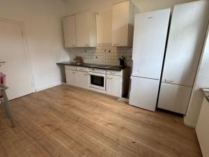 a kitchen with white appliances and a wooden floor at Platin Appartement in Wuppertal