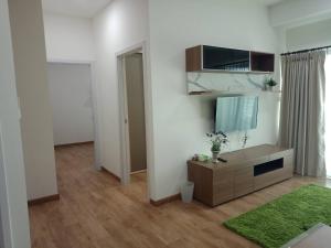 a living room with a television and a green rug at เพียร์93 in Ban Pak Khlong Si