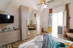 a living room with a bed and a flat screen tv at Kyma's House in Otranto in Otranto