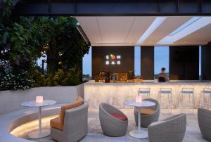 a restaurant with two tables and chairs and a bar at NH Hua Hin in Hua Hin