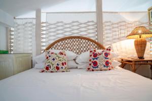 a bedroom with a white bed with pillows and a lamp at Villa Panorama in Symi