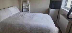a bedroom with a white bed and a television at Double room in rosyth in Rosyth