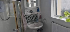 a bathroom with a sink and a toilet and a window at Double room in rosyth in Rosyth