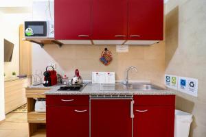 a kitchen with red cabinets and a sink at Kyma's House in Otranto in Otranto