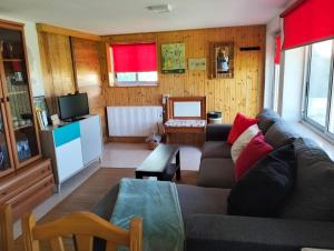 a living room with a couch and a tv at A Finquiña in Salcidos