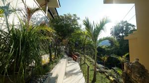 a walkway with palm trees on the side of a building at Bayu - Ocean View - Boutique Hotel in Karangasem