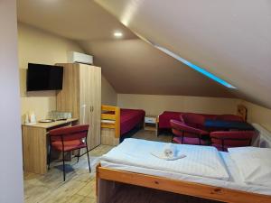 a room with a bed and chairs and a table at Hotel Taurus in Ostrava