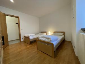a bedroom with two beds and a mirror at Appartamento Vadaione Est in Giustino
